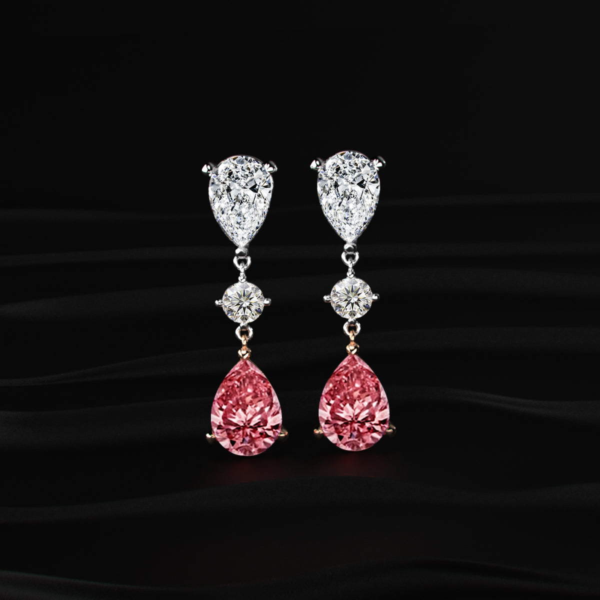 Pair of pink teardrop earrings with diamond accents on a black background